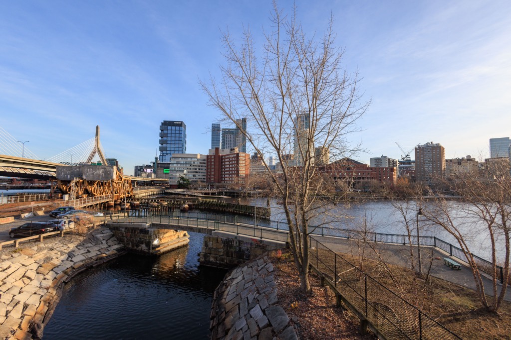 Boston buildings and the Zakim Bridge beside the river on a clear day
