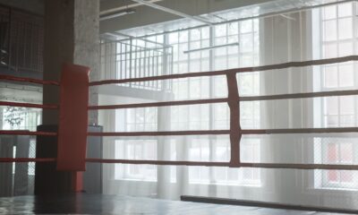 Empty boxing ring in a bright gym with tall windows