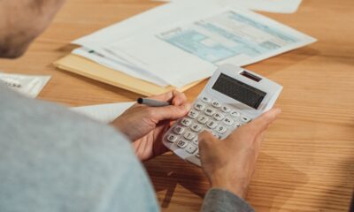 Hands using a calculator beside financial paperwork on a desk