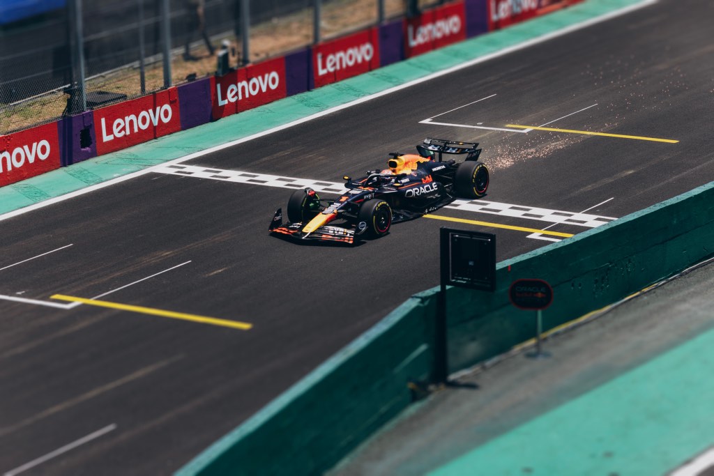 A Formula 1 car racing along a track with sparks behind it