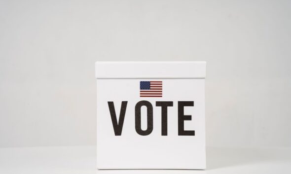 White ballot box marked Vote with an American flag design