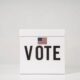 White ballot box marked Vote with an American flag design