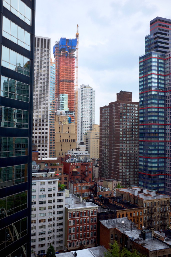 New York City buildings of different heights beside a construction crane