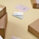Plain cardboard boxes with white labels on a yellow surface
