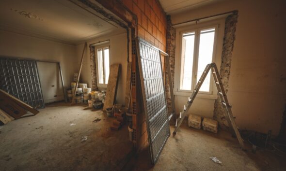 Unfinished interior with exposed masonry, building materials and a ladder