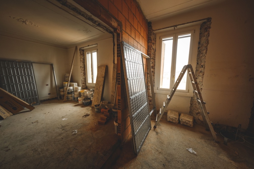 Unfinished interior with exposed masonry, building materials and a ladder