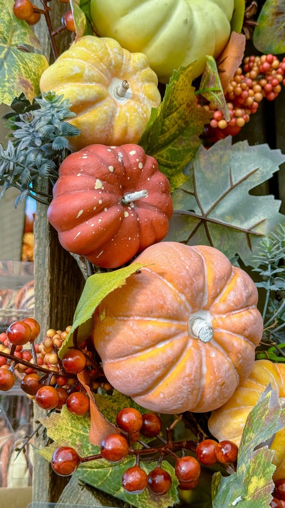 Orange pumpkins and colorful autumn leaves in a seasonal display