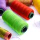 Spools of green, red, purple, yellow and pink sewing thread