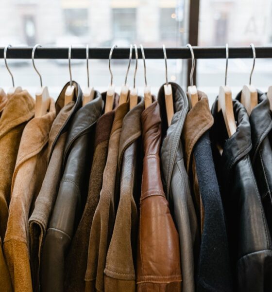 Leather and suede jackets hanging on a clothing rack