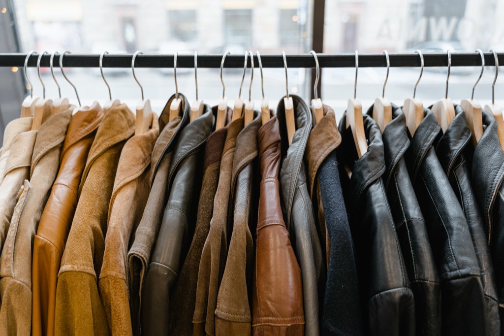 Leather and suede jackets hanging on a clothing rack