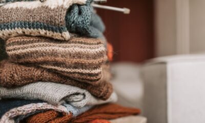 Folded knitted garments with knitting needles resting on top