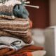 Folded knitted garments with knitting needles resting on top